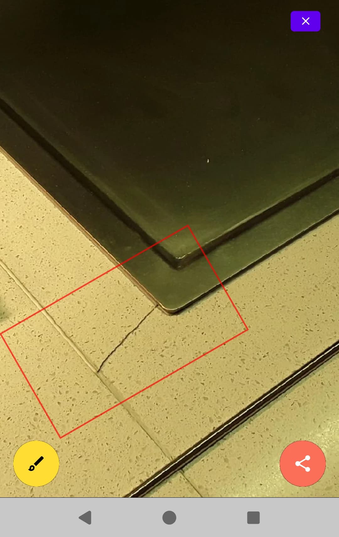Photo d’une fissure dans un carrelage, encadrée en rouge avec l’outil d’annotation